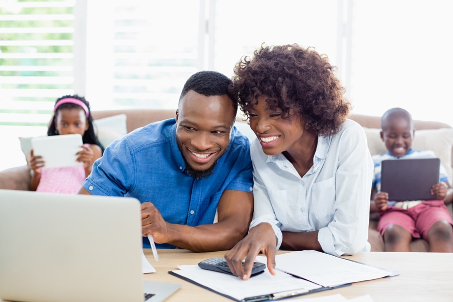 Couple doing research on laptops about air conditioners.