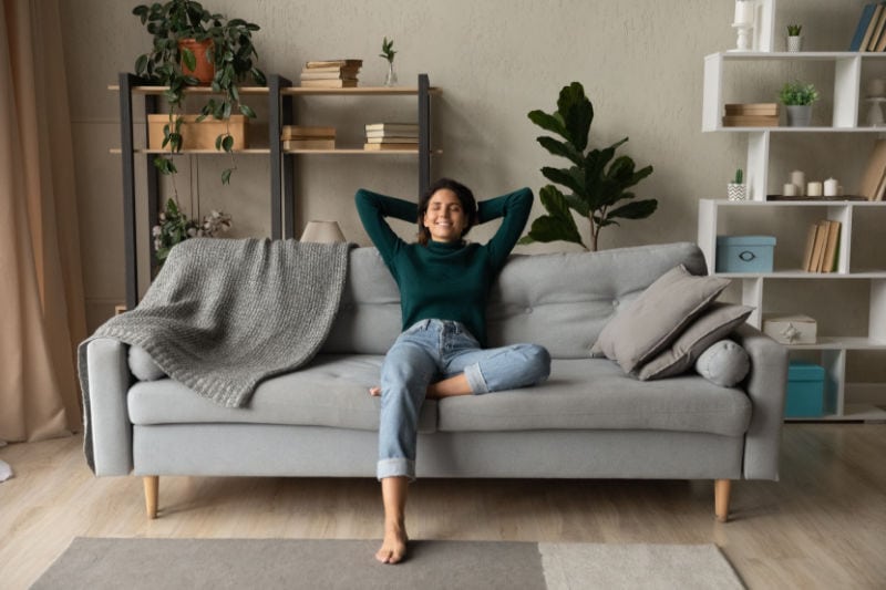 How a Whole-House Humidifier Keeps You Healthy. Woman sitting comfortably in her home.