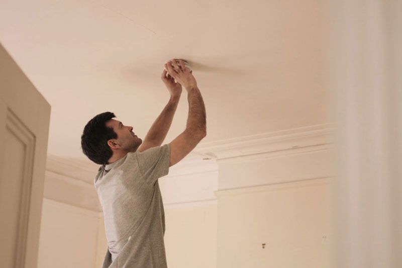 Someone changing batters in smoke detector. Video - When Do I Need to Replace the Batteries in My Smoke Detector?