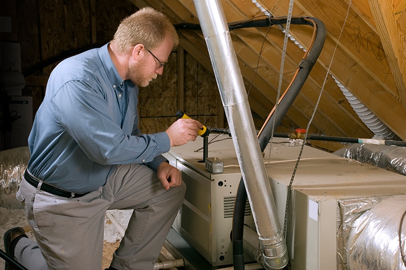 HVAC technician performing maintenance on furnace.